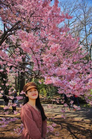 Japanese Speech Contest Participant Uyen Trinh next to a cherry blossom in Tokyo