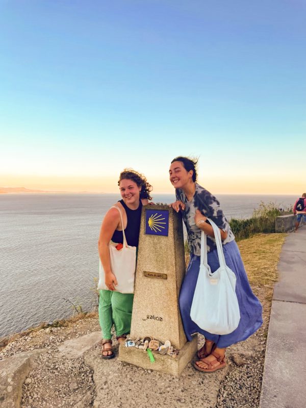 Two women at a marker along the Camino de Santiago