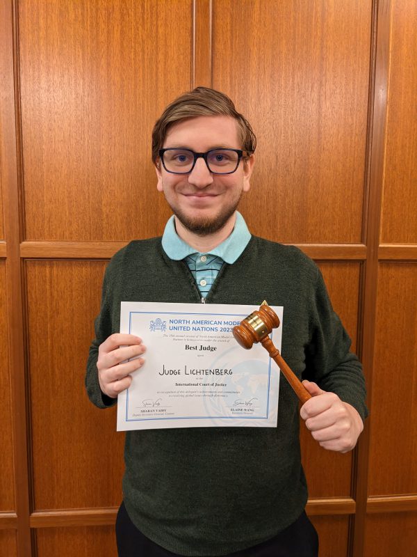 Thomas Lichtenberg holds a gavel and certificate awarded to the Best Judge at the North American Model United Nations Conference