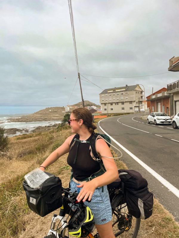 One female student looking at the ocean at the Camino Finisterre along the Camino de Santiago trail