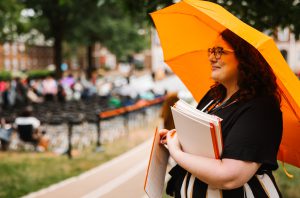 Best Small Employers: Amanda Bidinger uses an umbrella in the rain at Commencement