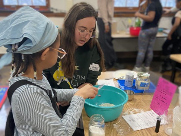 Civic Engagement Scholar Hannah Parsons cooks with a student in the Club Grub kitchen