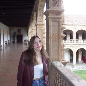Ella MIller '26 stands in the historic inner courtyard of the Colegio Arzobispo Fonseca in Salamanca, Spain, during her study abroad experience