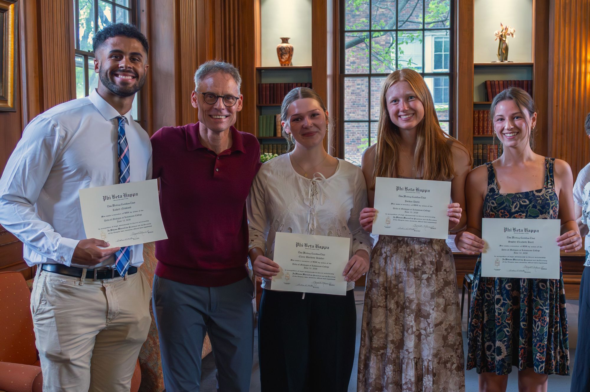Four students and a faculty member pose with the student certificates for Phi Beta Kappa