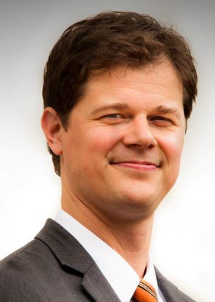 Headshot of Andy Miller '99 Associate Vice President for Development. A blurred Gray background.