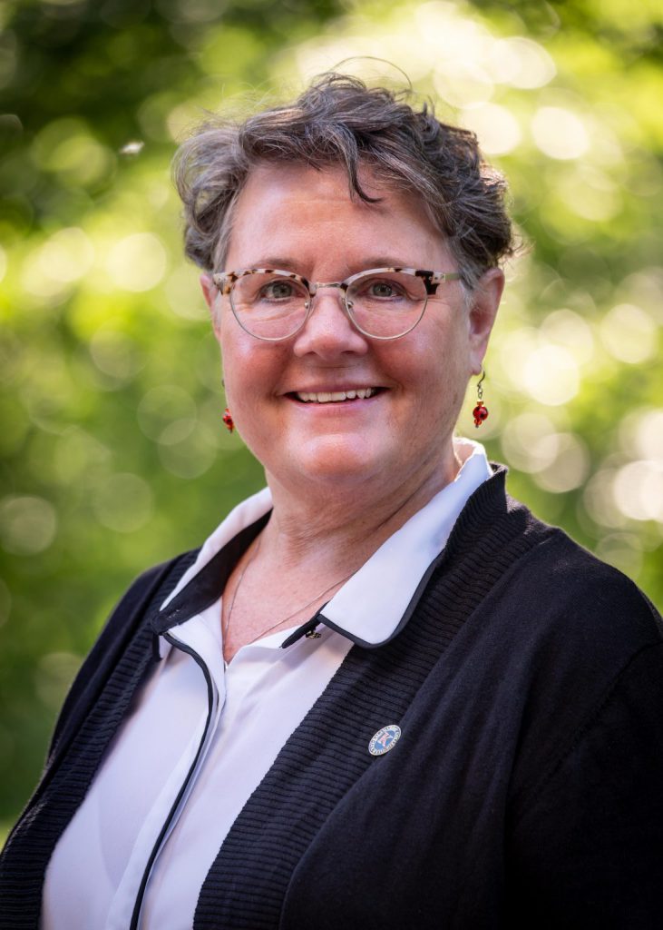 Headshot of Desma Caudill Manager, Donor Relations. A blurred natural setting is visible behind her.