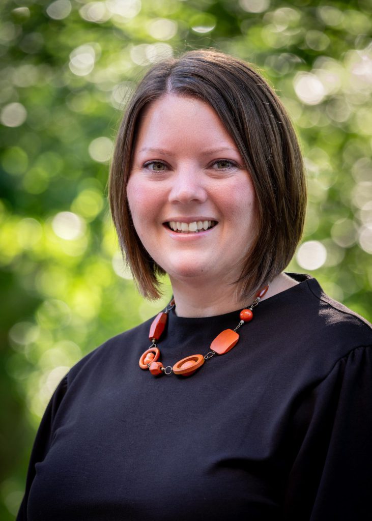 Headshot of Lindsay (Mutch) O’Donohue Senior Director, Constituent Programs and Annual Giving. A blurred natural setting is visible behind her.
