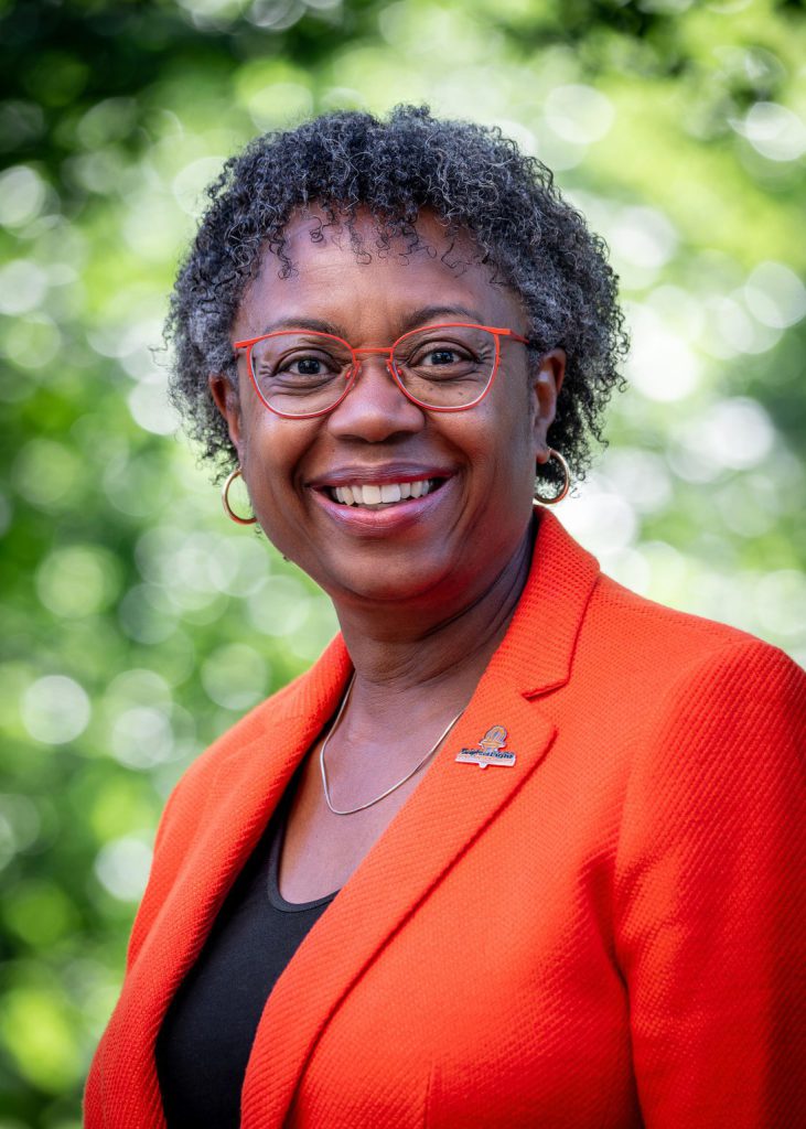 Headshot of Karen Isble, the Vice President for College Advancement. A blurred natural setting is visible behind her.