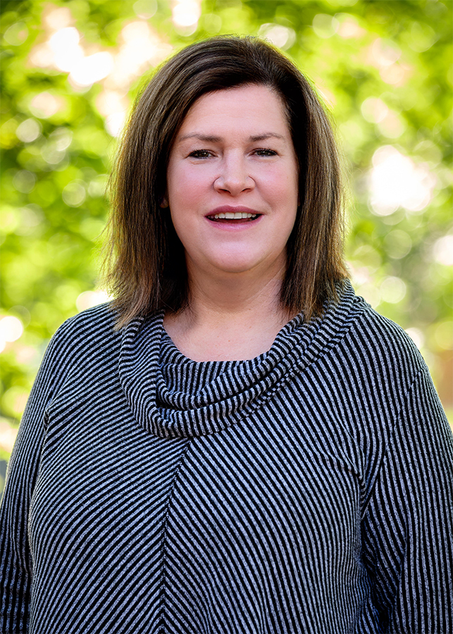 Headshot of Laurel Palmer Director, Kalamazoo College Fund. A blurred natural setting is visible behind her.