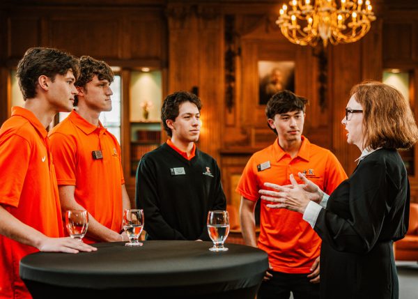 Four president student ambassadors with the president at a gathering