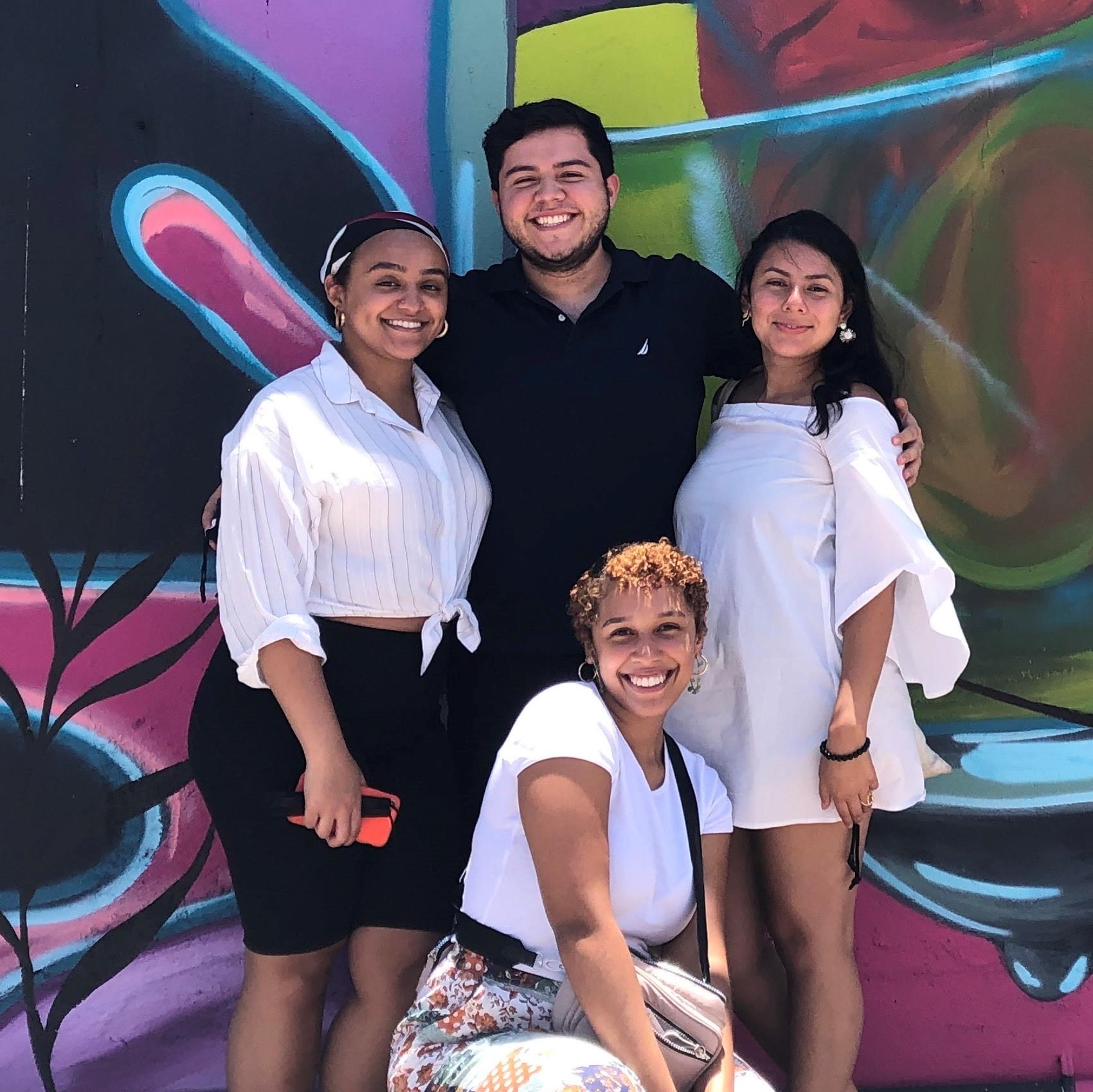 Four students against a colorful wall in Puerto Rico