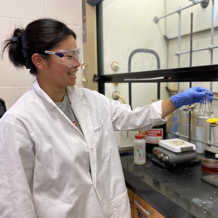 Female student in lab coat doing research
