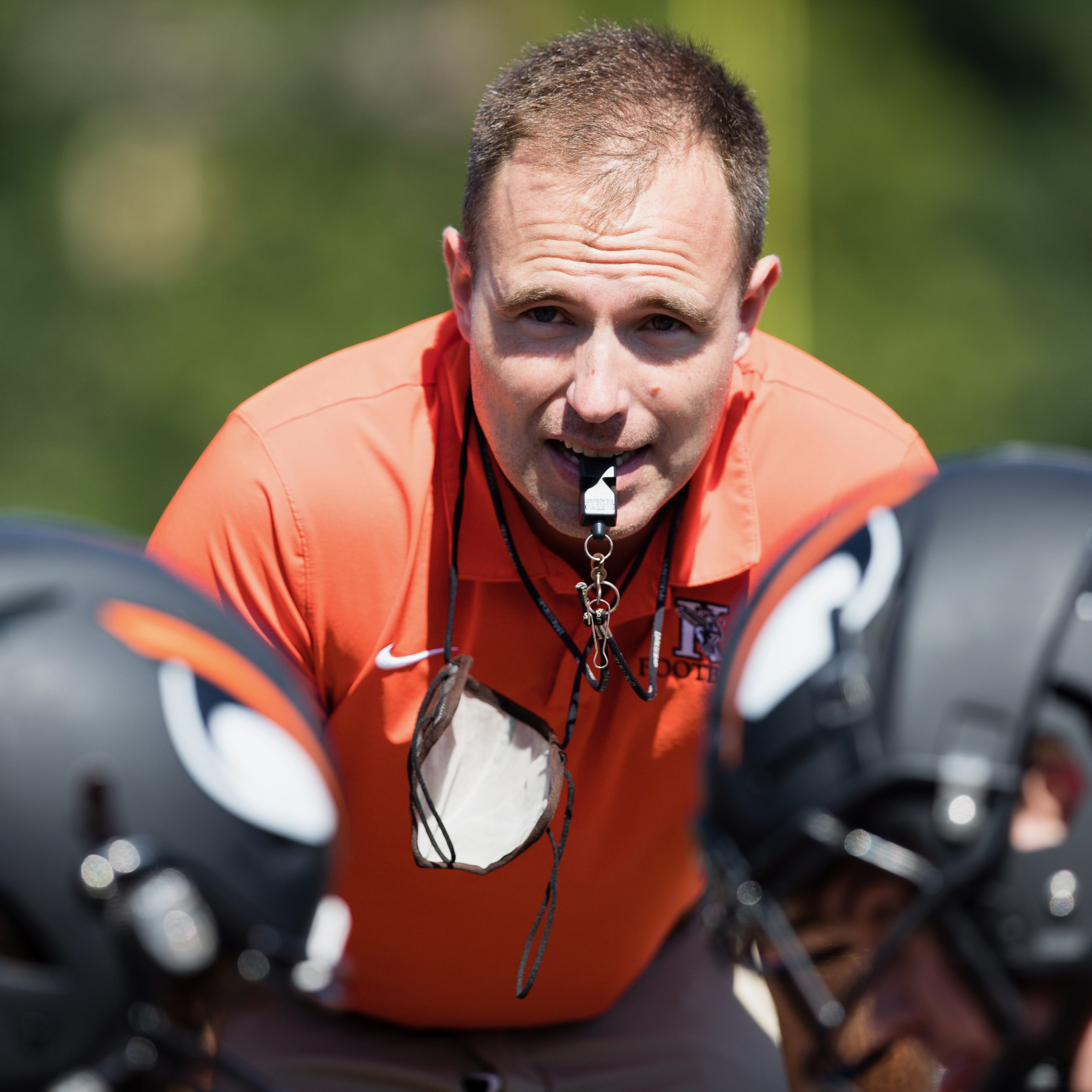 Coach John Krajacic with two football players