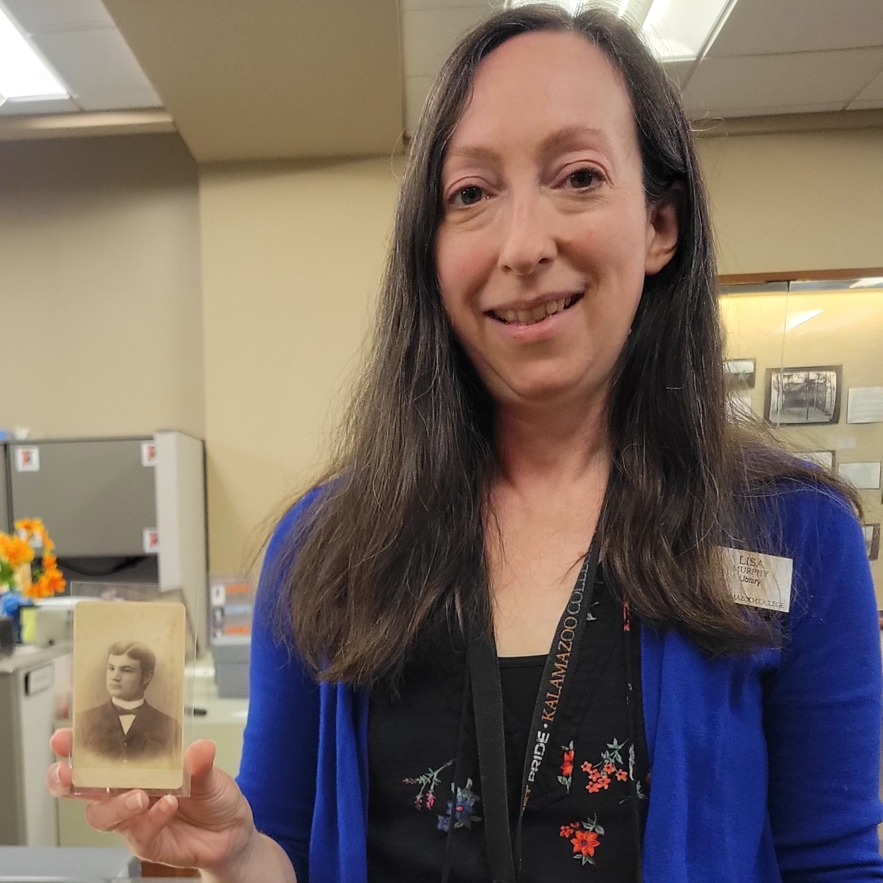 Archivist Lisa Murphy holds a portrait of William Des Autels