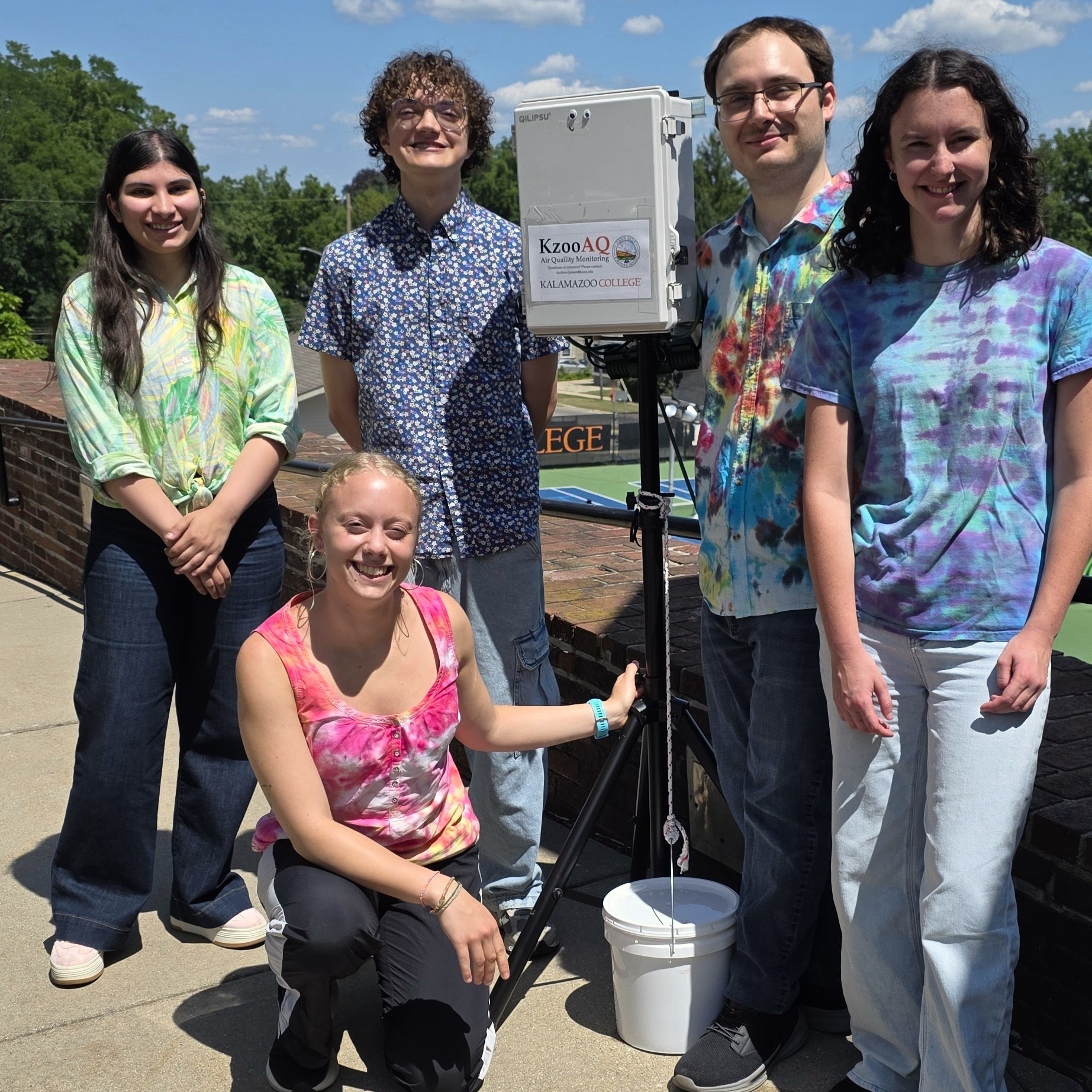 Students pose with an air-quality monitor